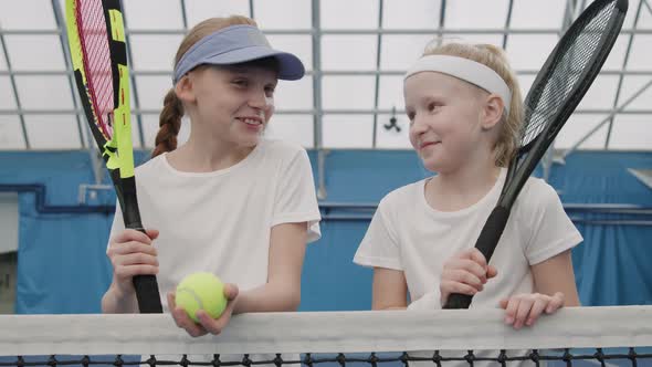 Portrait Of Little Girls On Tennis Court