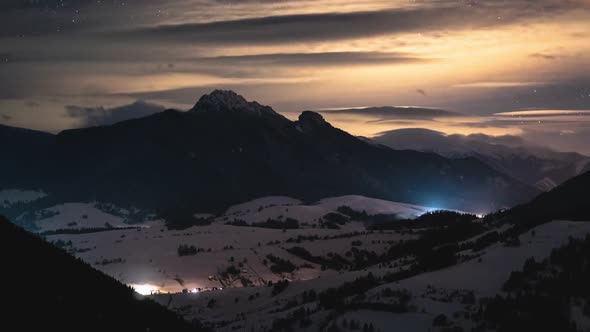 Magic Starry Night Sky with Stars in Winter Alpine Mountains with Foggy Clouds