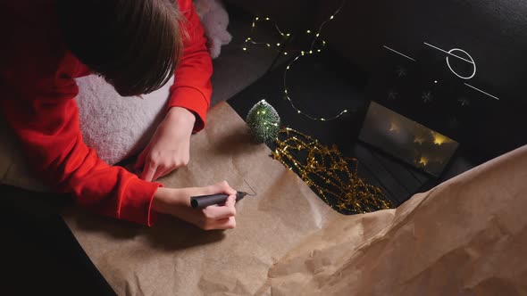 Teenage Boy Writing Long Letter To Santa