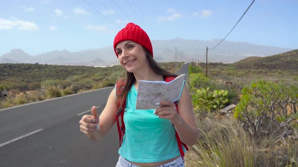 Traveler Woman Hitchhiking on a Sunny Road and Walking