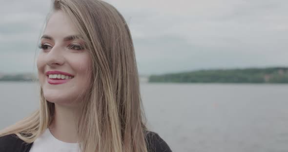 Pretty Girl Looks Aside Rejoices in the Memories and Corrects Hair at Seaside