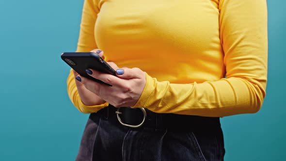 Hands of Woman Using Mobile Phone on Blue Background