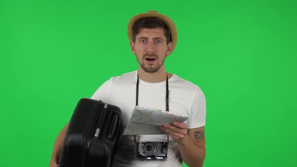 Portrait of Tourist with Suitcase and Retrocamera Carefully Examines Map,then Happy Looking at