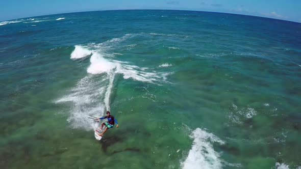 Aerial view of a man kitesurfing in Hawaii.