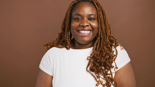 Close Up Studio Portrait of Laughing African American Woman Brown Background Slow Motion