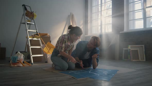 Cheerful Couple Planning Home Repair Inside
