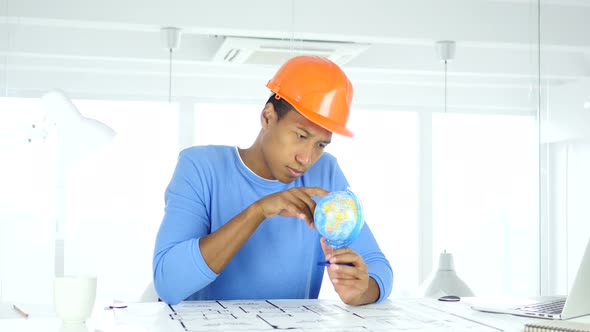 Afro-American Architectural Engineer Reading World Globe with attention