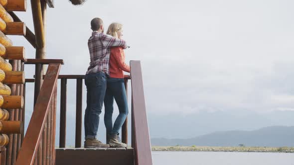 Caucasian couple spending time at home together, huggind and looking at the view