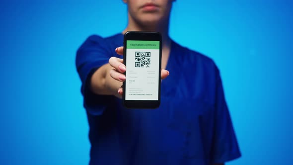 Woman Surgeon in Medical Uniform Showing Vaccination Passport with Qr Code on Phone International