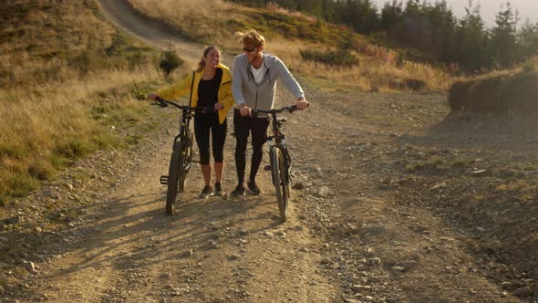 Girl and Guy with Bikes Going on Road Cyclists Taking Rest After Exercising