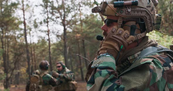 Soldier in Military Uniform Put on Tactical Helmet in a Temporary Forest Base