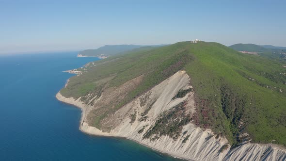 Aerial View of Steep Slope with Trees Near Coast Line Sea Seashore with Rocks