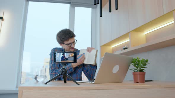Blogger leads a video blog using a smartphone, using a laptop at home. online chat with subscribers