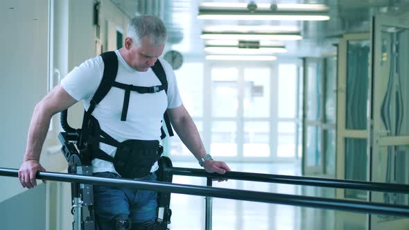 Handicapped Man is Learning to Walk in the Exoskeleton