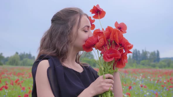 Portrait Pretty Young Woman Holding and Sniffing Bouquet of Flowers in Hands Looking in the Camera