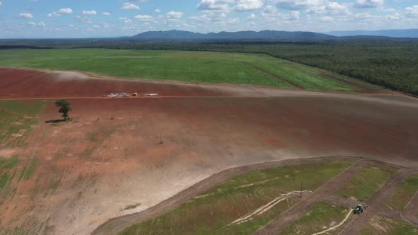 Land cleared by deforestation of the Brazilian Savannah to plow and plant soybeans - aerial pull bac