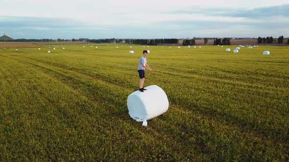 Cute Little Boy Jumps And Plays On Row Of Bales