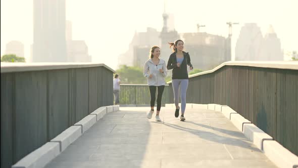 4K Asian woman friends jogging exercise together at public park in the morning.