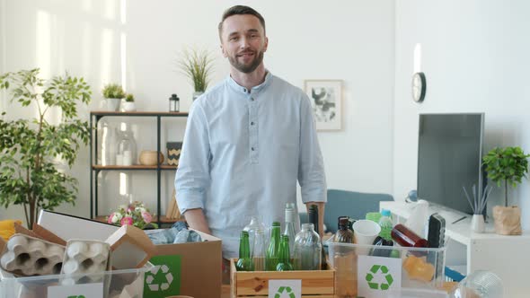 Slow Motion Portrait of Responsible Young Man Standing at Home with Containers of Waste for