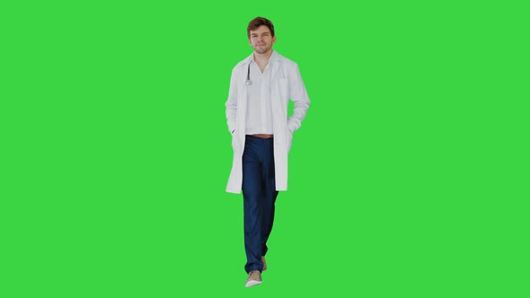 Male Doctor in White Coat Walking with Hands in Pockets Looking Straight Ahead on a Green Screen