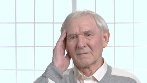 Cheerless Older Man Touching His Temple.