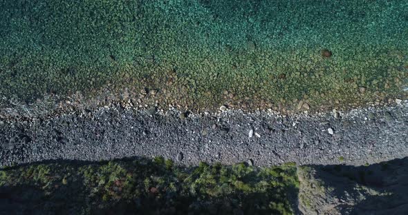 Top View of Sea Waves Break on High Cliff of a Rocky Mountain and a Yacht is Sailing Nearby