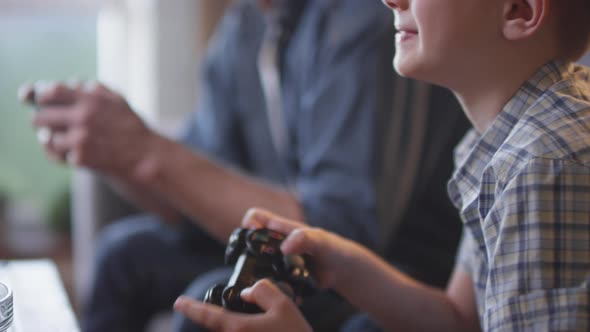 Cheerful Boy Playing Video Game with Father