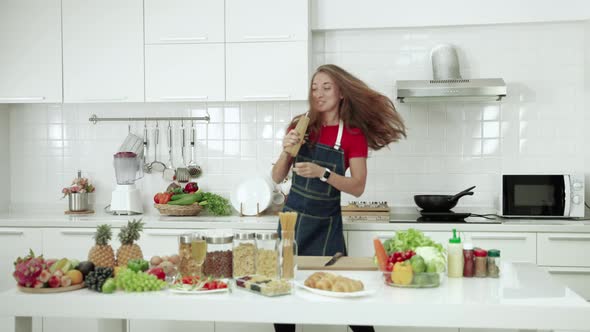 The young woman entered the kitchen, made the meal and danced in joy, fun in the routine