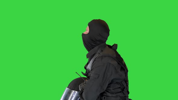 Riot Policeman Sitting with Helmet Off Having Rest on a Green Screen Chroma Key