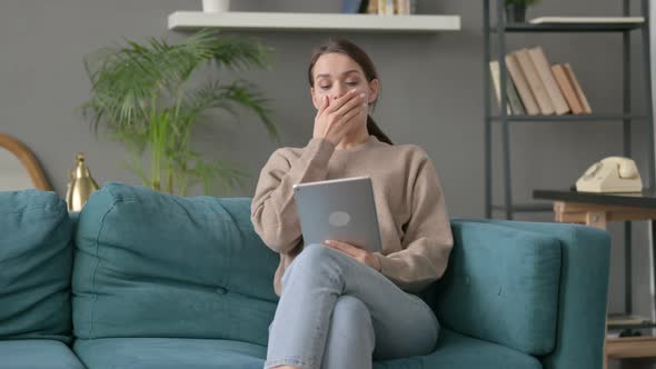 Woman Having Loss on Tablet on Sofa