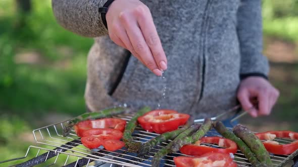 Making Grilled Vegetables  Salting Asparagus and Red Pepper on a Charcoal Grill