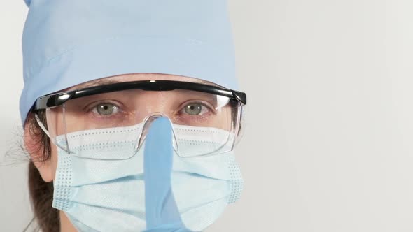 woman in a disposable medical mask, glasses and a textile cap 