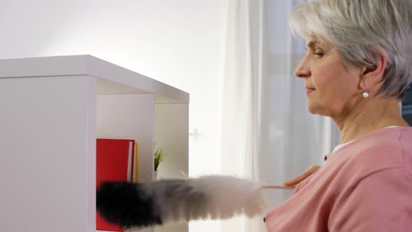 Senior Woman with Duster Cleaning Rack at Home