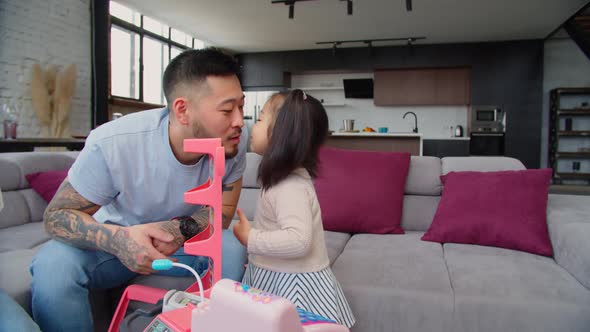 Caring Asian Dad Babysitting Toddler Daughter at Home