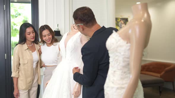 4K Asian woman lesbian couple choosing wedding dress together at bridal shop