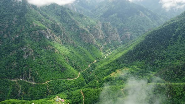 Flying Through Clouds Above Mountain Forest with Morning Mist Aerial Top View