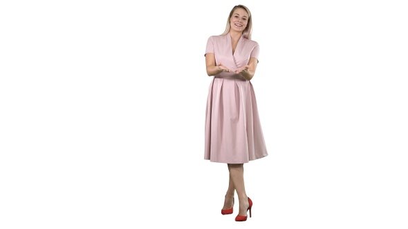 Happy blonde woman in pink talking to camera and pointing