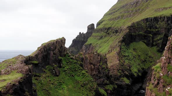 Aerial Back View of Huge Cliffs in Faroe Islands Green Rocky Mountainpowerful Ocean Wavesin a Cloudy