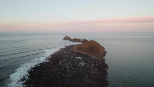 AERIAL: Wide circle of Worm's Head during sunrise, Rhossili Gower, 4k, Drone