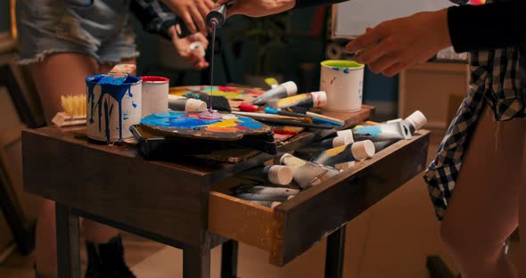 Closeup of Table Drawer of Artist Painter with Scattered Disordered Paints in Tube Brushes Artistic