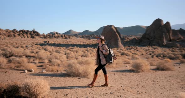 Young Woman Is Hiking in Desert Rocky Park in Summer on Sunrise. Nature 