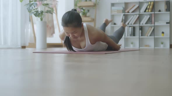 Asian woman practicing yoga pose Bow online course at home