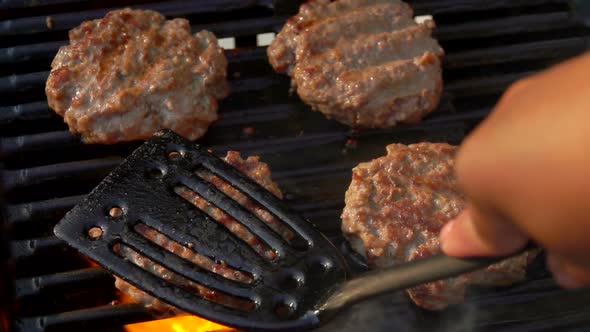 Tasty Beef Burgers Flipping on the Grill.