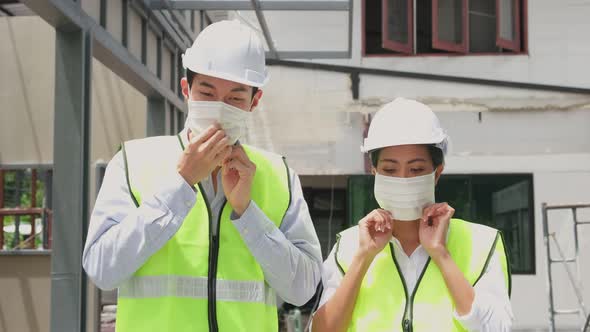 Asian workers people wearing protective face mask onsite of architecture due to covid pandemic.
