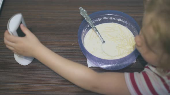 Girl Eats Milk Pasta Playing with Baby Monitor at Table