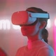 Young woman experiencing virtual reality wearing goggles with neon sign in the background - VideoHive Item for Sale