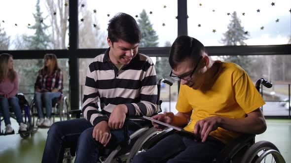Joyful Teen Boys with Cerebral Palsy Using Tablet