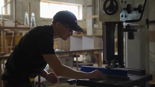 Carpentry Workshop  Worker Cutting Wooden Details with an Automatic Saw