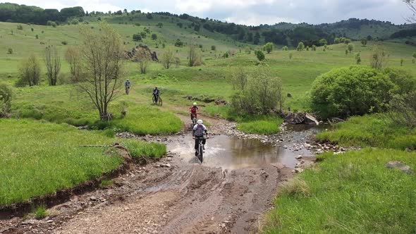 The Cyclists On Bikes Ride Up In The Village