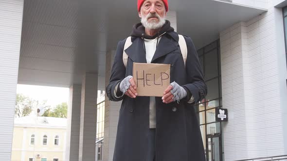 Senior Sad Man Without Shelter with Cardboard Sign HELP